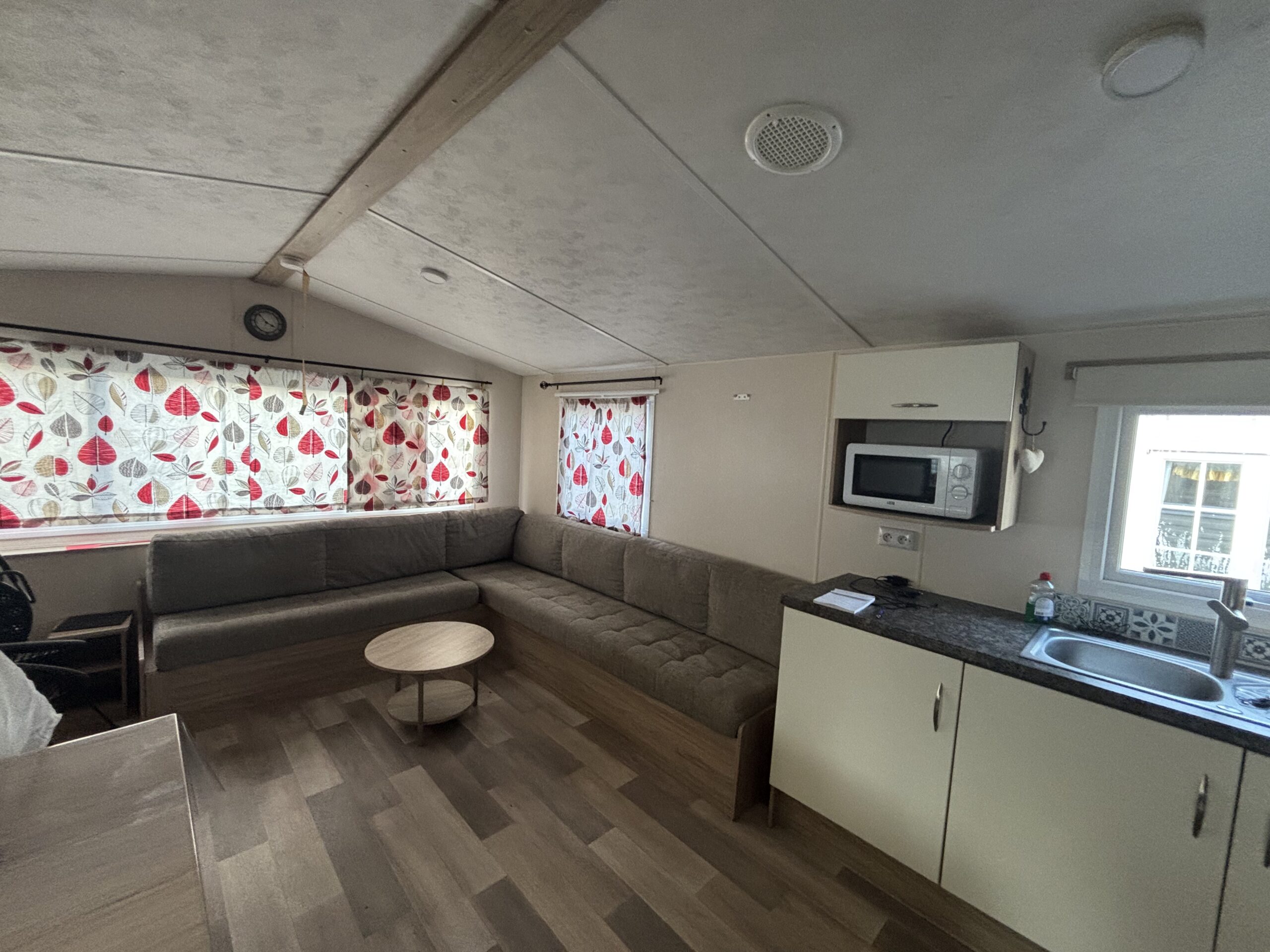 Séjour avec vue sur le salon et la cuisine du mobil-home EUROPA ROSEWOOD sur emplacement au camping de La Tentation