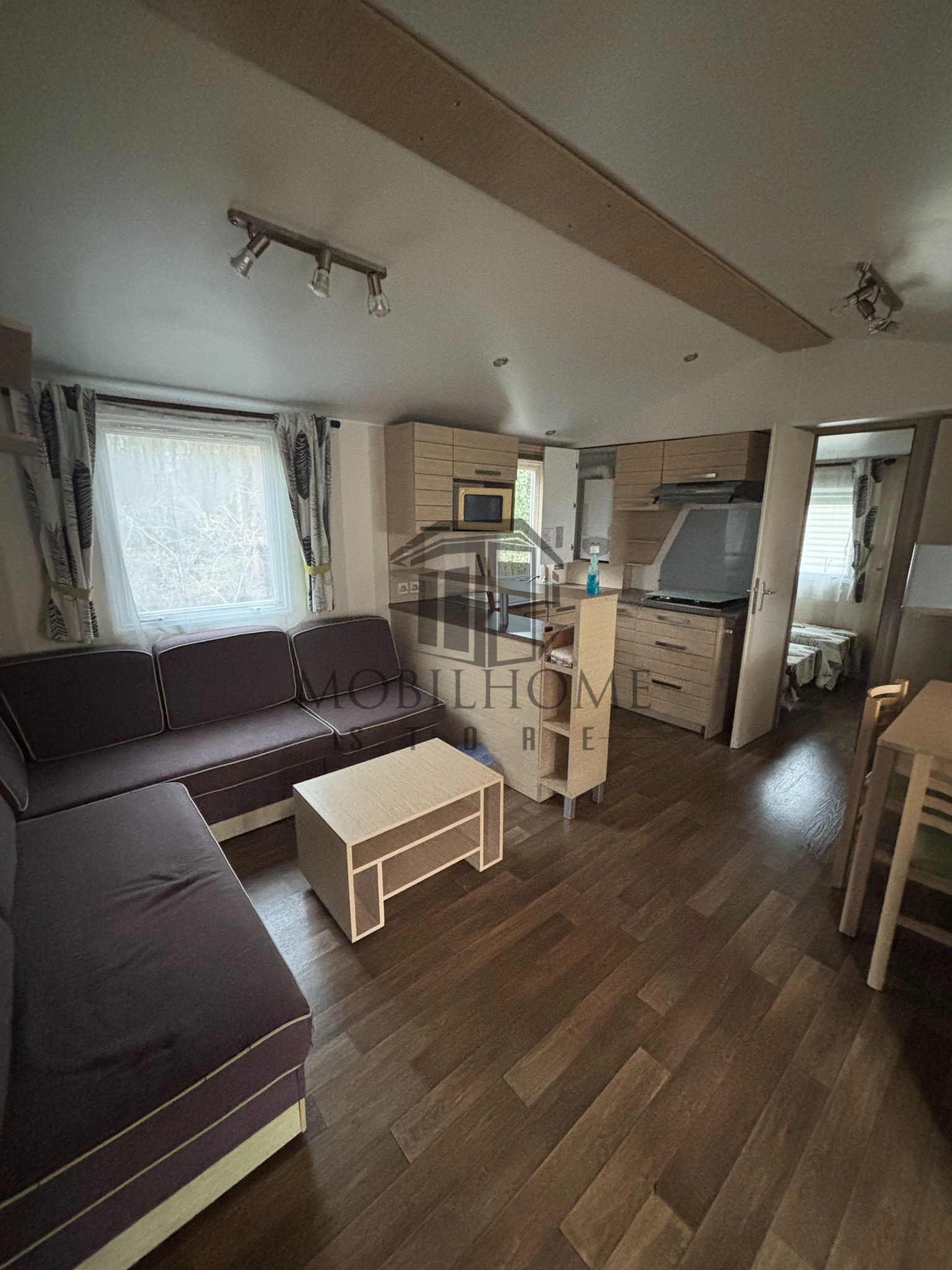 Séjour avec vue sur la cuisine du mobil-home IRM SUPER CELINA CONFORT AVANE sur emplacement au camping de La Tentation