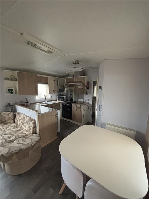 Séjour avec vue sur le coin repas et la cuisine du mobil-home SILVERDALE SUPER CL sur emplacement au camping de La Tentation