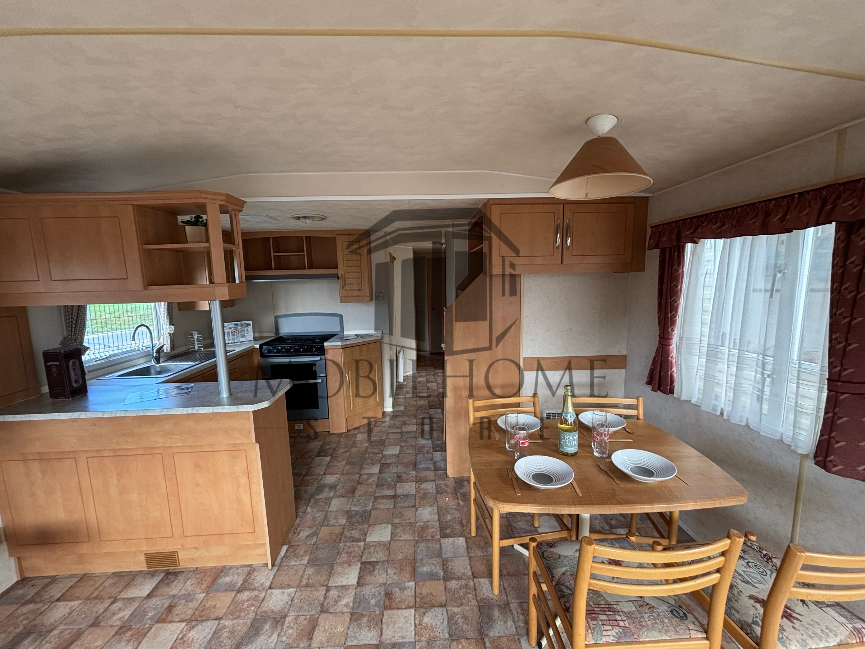 Séjour avec vue sur le coin repas et la cuisine du mobil-home Atlas Mirage